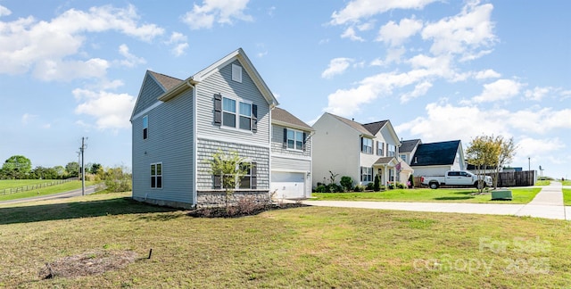 view of side of property featuring an attached garage, a yard, and driveway