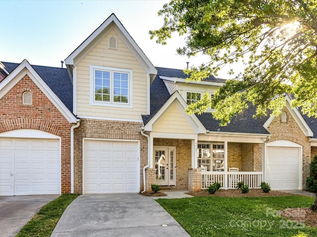 view of front facade with covered porch, concrete driveway, a shingled roof, and brick siding