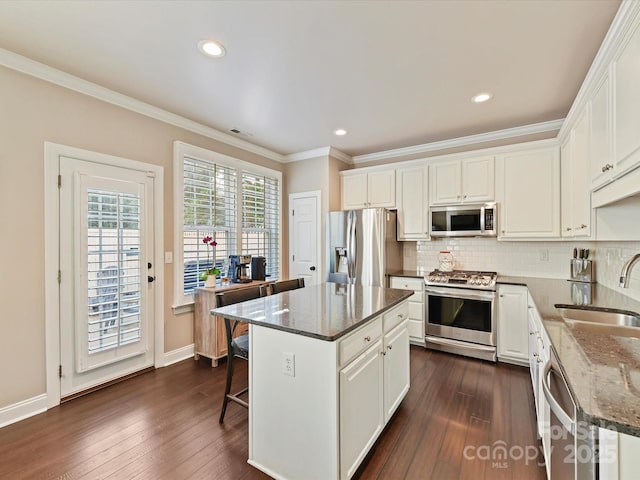 kitchen with dark wood-style floors, a sink, white cabinets, and stainless steel appliances