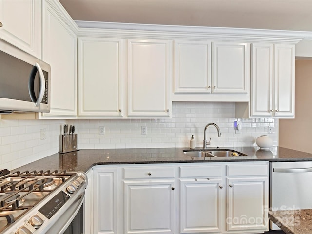 kitchen with white cabinetry, stainless steel appliances, backsplash, and a sink