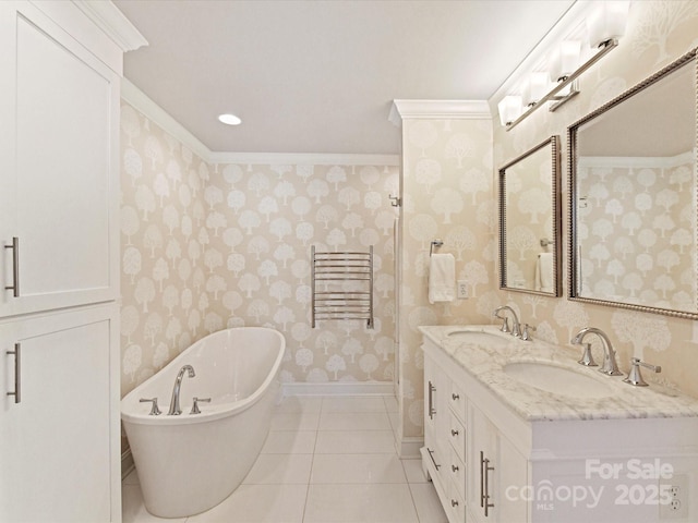 bathroom with wallpapered walls, a sink, a freestanding tub, and tile patterned floors