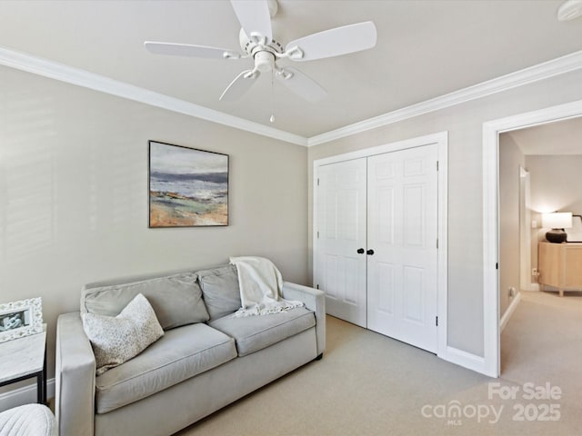 carpeted living area with ornamental molding, ceiling fan, and baseboards