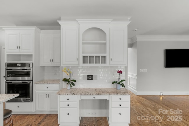 9008 Skipaway Dr, Waxhaw, NC 28173 - kitchen with open shelves, stainless steel double oven, wood finished floors, crown molding, and decorative backsplash