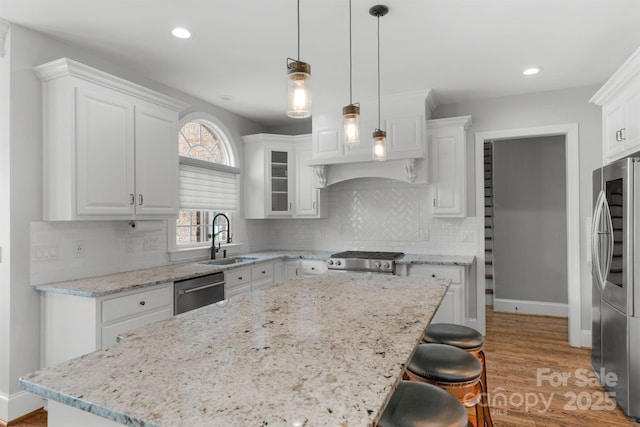 9008 Skipaway Dr, Waxhaw, NC 28173 - kitchen with a sink, appliances with stainless steel finishes, white cabinetry, light wood finished floors, and baseboards