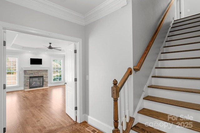 9008 Skipaway Dr, Waxhaw, NC 28173 - stairs featuring a ceiling fan, ornamental molding, wood finished floors, a fireplace, and baseboards