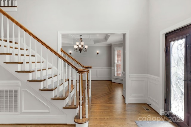 9008 Skipaway Dr, Waxhaw, NC 28173 - foyer entrance featuring a chandelier, wainscoting, stairway, crown molding, and a decorative wall