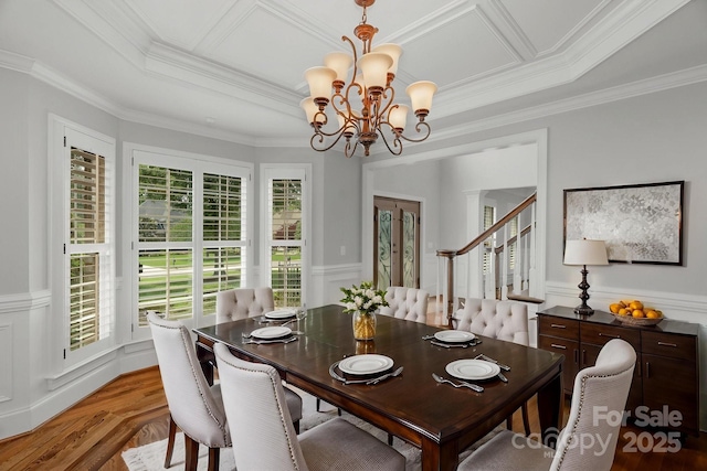 9008 Skipaway Dr, Waxhaw, NC 28173 - dining room featuring a chandelier, plenty of natural light, crown molding, a wainscoted wall, and light wood finished floors