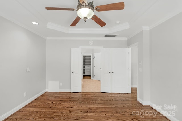9008 Skipaway Dr, Waxhaw, NC 28173 - unfurnished bedroom featuring a raised ceiling, crown molding, wood finished floors, baseboards, and recessed lighting