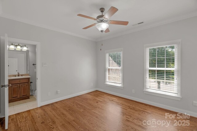 9008 Skipaway Dr, Waxhaw, NC 28173 - unfurnished bedroom featuring a sink, crown molding, light wood finished floors, baseboards, and ensuite bath