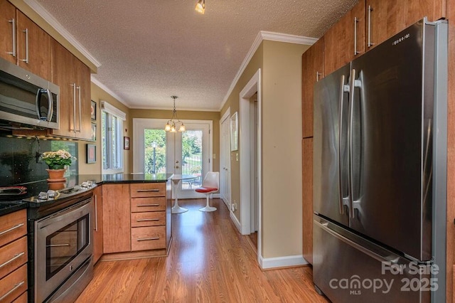 102 Glenbrook Dr, Hendersonville, NC 28739 - kitchen with stainless steel appliances, a peninsula, brown cabinetry, and light wood finished floors