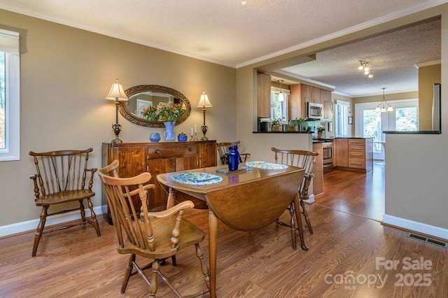 102 Glenbrook Dr, Hendersonville, NC 28739 - dining area with a textured ceiling, ornamental molding, visible vents, wood finished floors, and baseboards