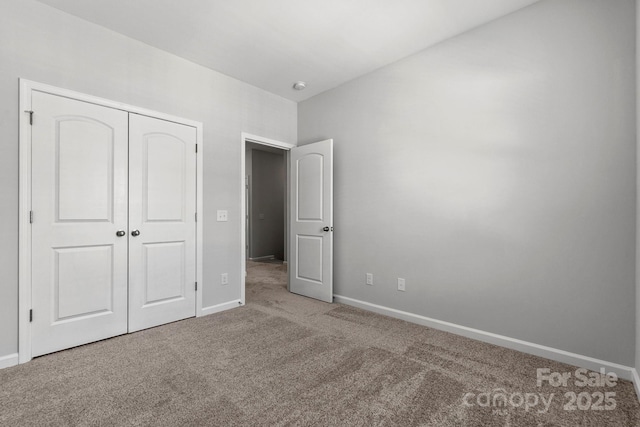 unfurnished bedroom featuring carpet floors, baseboards, and a closet