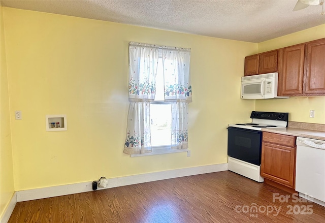 kitchen featuring a wealth of natural light, white appliances, and dark wood finished floors