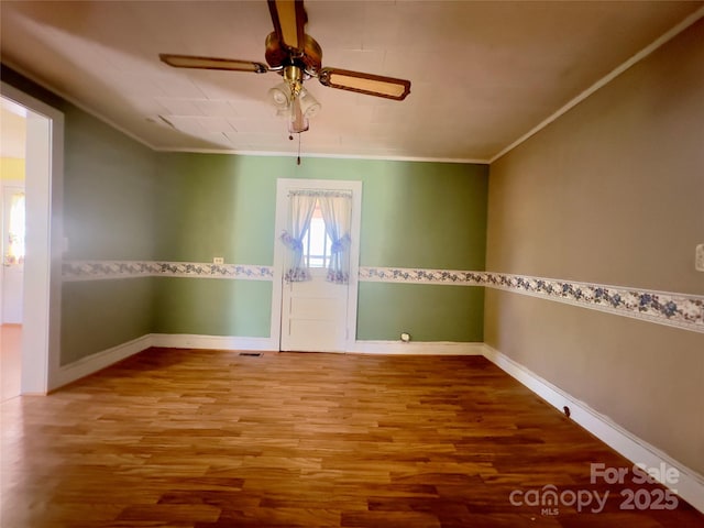 spare room with wood finished floors, ceiling fan, and ornamental molding