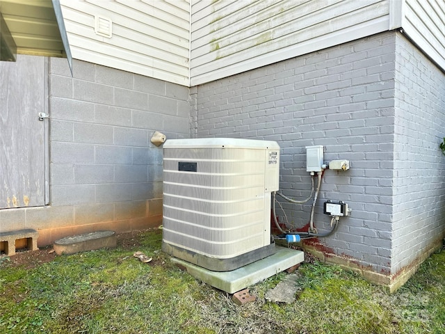 exterior details with brick siding, cooling unit, and crawl space