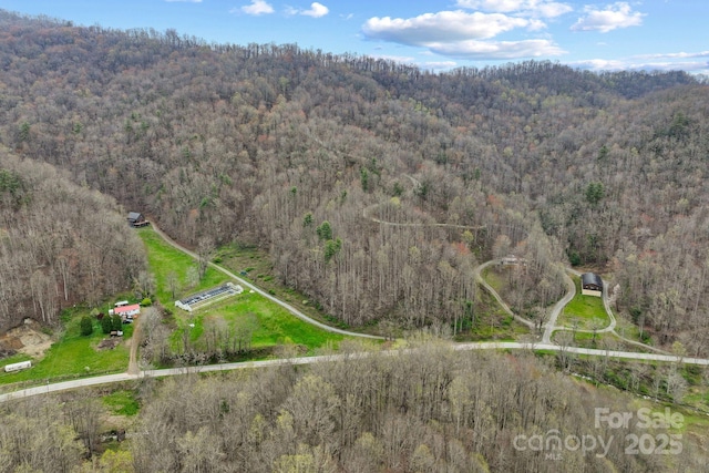 drone / aerial view featuring a wooded view