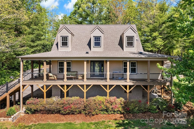 rear view of house featuring roof with shingles and a wooden deck