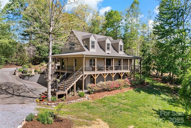 exterior space featuring a porch, a yard, driveway, and stairs