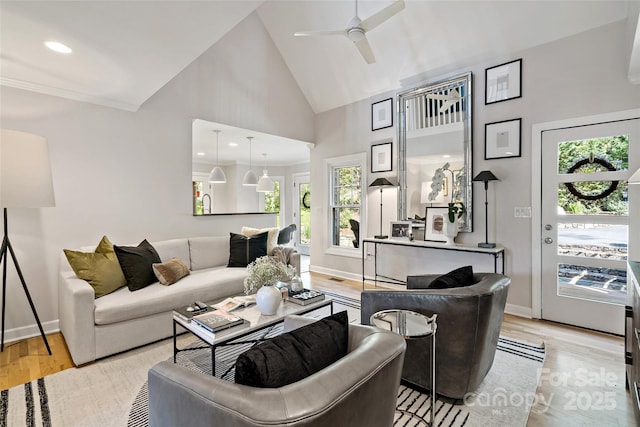 living area with baseboards, ceiling fan, high vaulted ceiling, recessed lighting, and light wood-style flooring