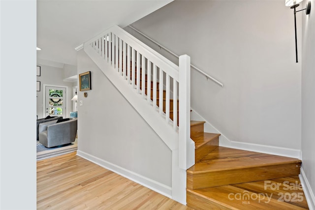 stairway featuring baseboards and wood finished floors