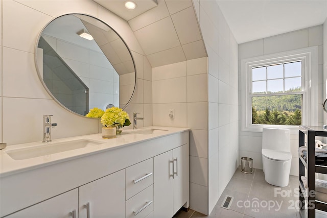 full bathroom with a sink, tile walls, tile patterned flooring, and double vanity