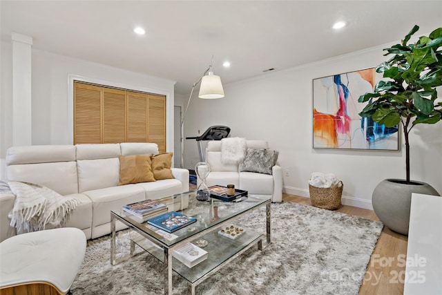 living area featuring recessed lighting, baseboards, ornamental molding, and wood finished floors