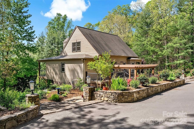 exterior space with roof with shingles and a patio area