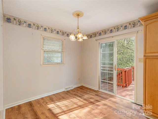 12 Birchwood Ln, Asheville, NC 28805 - empty room with visible vents, light wood finished floors, baseboards, and an inviting chandelier