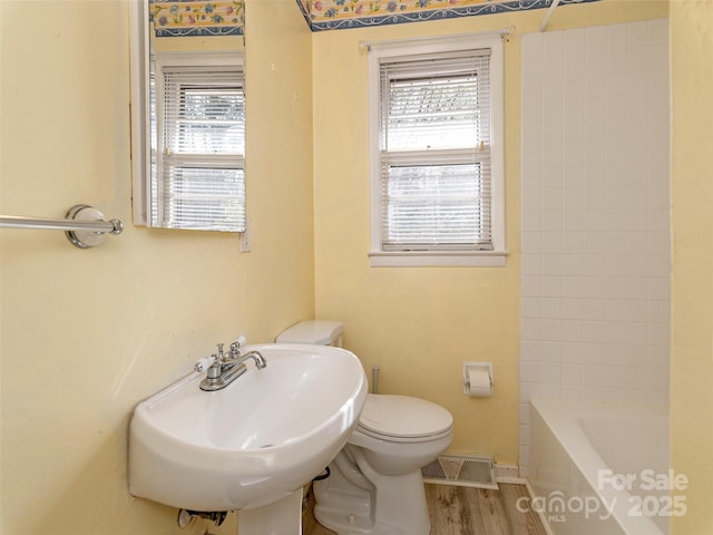12 Birchwood Ln, Asheville, NC 28805 - bathroom with visible vents, wood finished floors, toilet, and a healthy amount of sunlight
