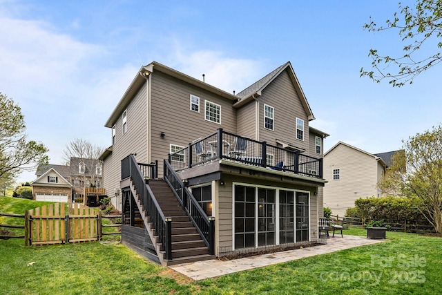 rear view of house featuring a lawn, fence, a patio, a wooden deck, and stairs