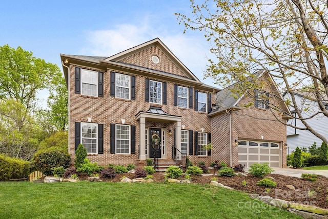 colonial home featuring brick siding, driveway, and a front lawn