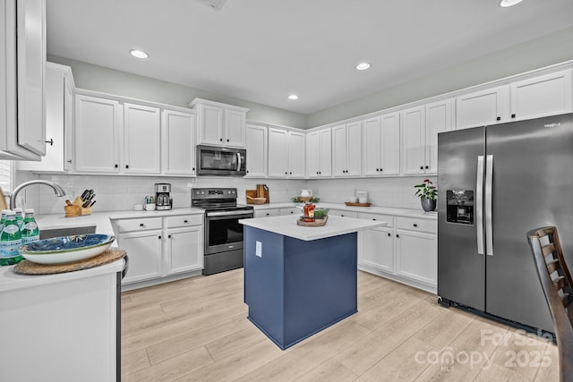 1809 Robbins Meadows Dr, Waxhaw, NC 28173 - kitchen featuring appliances with stainless steel finishes, white cabinetry, decorative backsplash, light wood-style flooring, and recessed lighting
