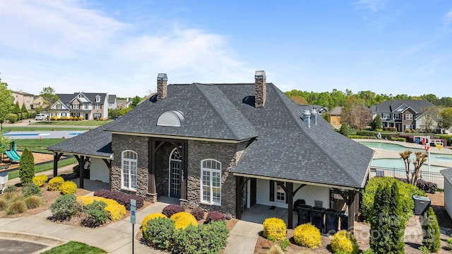 1809 Robbins Meadows Dr, Waxhaw, NC 28173 - view of front of house with stone siding, a chimney, a residential view, and a shingled roof