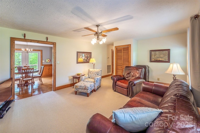 207 New Orleans Blvd, Morganton, NC 28655 - carpeted living room featuring ceiling fan with notable chandelier, baseboards, and a textured ceiling
