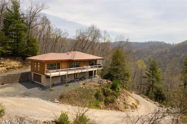 263 Mine Cove Rd, Spruce Pine, NC 28777 - back of house with a deck, driveway, a forest view, and an attached garage