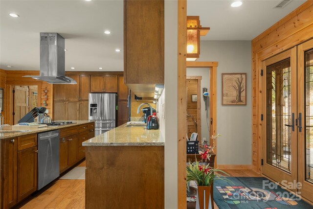 263 Mine Cove Rd, Spruce Pine, NC 28777 - kitchen featuring light stone countertops, stainless steel appliances, brown cabinets, island exhaust hood, and a sink