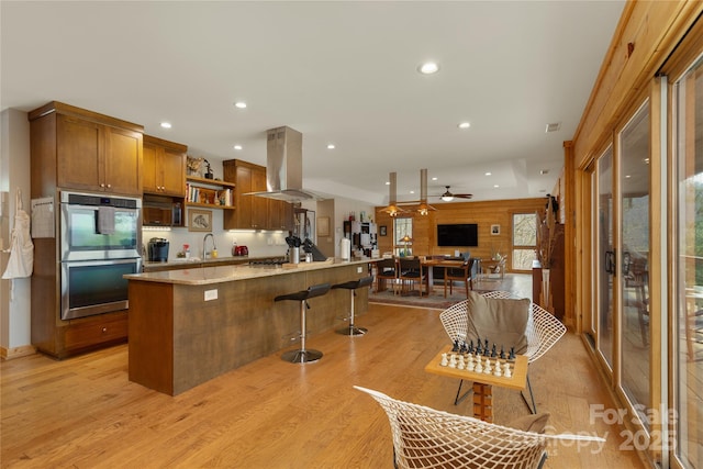 263 Mine Cove Rd, Spruce Pine, NC 28777 - kitchen with open shelves, island range hood, stainless steel double oven, light wood-type flooring, and recessed lighting