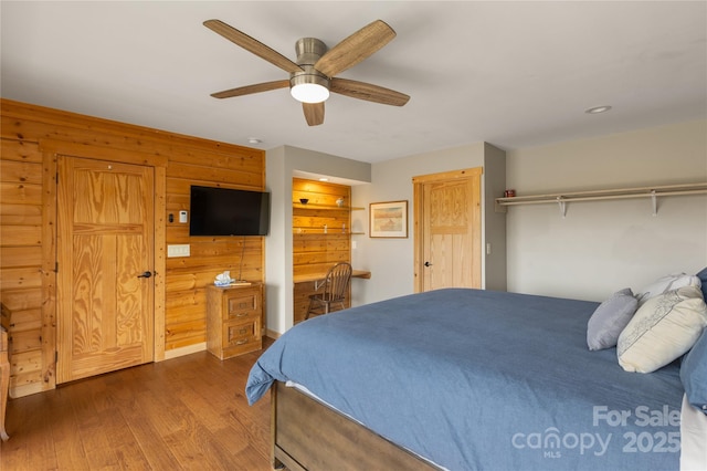 263 Mine Cove Rd, Spruce Pine, NC 28777 - bedroom with wooden walls, a ceiling fan, wood finished floors, and ensuite bath