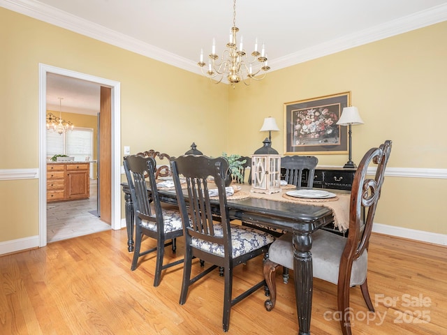 dining area with baseboards, an inviting chandelier, and crown molding