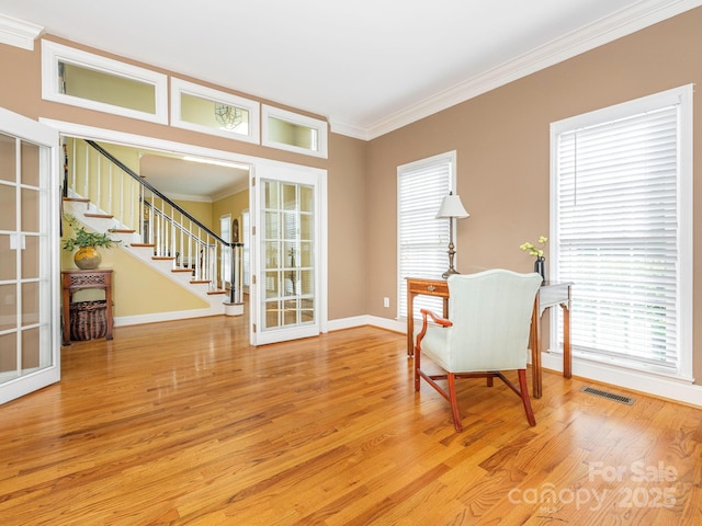 living area with stairway, french doors, crown molding, visible vents, and light wood finished floors