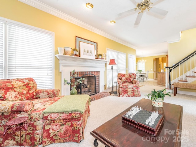 living area with ornamental molding, stairway, carpet, and ceiling fan with notable chandelier