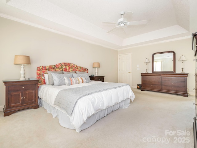 bedroom featuring crown molding, ceiling fan, carpet, a tray ceiling, and baseboards