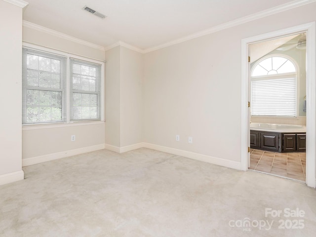 empty room featuring crown molding, visible vents, baseboards, and light colored carpet