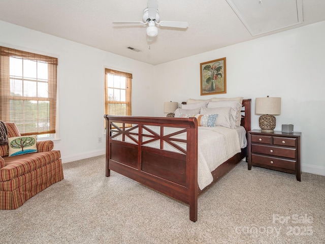 bedroom featuring baseboards, attic access, a ceiling fan, visible vents, and light colored carpet