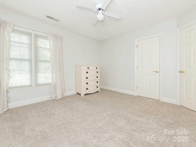 unfurnished bedroom with ceiling fan, baseboards, visible vents, and carpet floors
