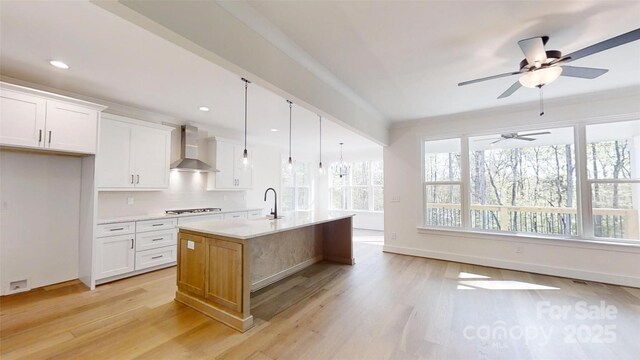 472 Bellingshire Dr, Mount Ulla, NC 28125 - kitchen featuring light countertops, a ceiling fan, light wood-style floors, wall chimney exhaust hood, and stovetop