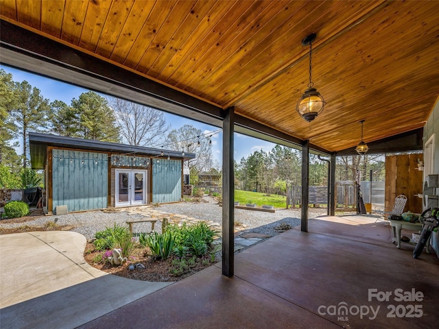 view of patio with french doors, fence, and an outbuilding
