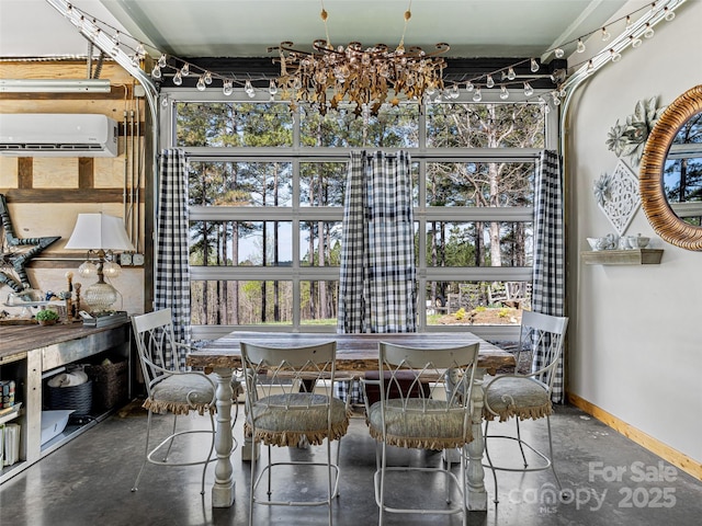 dining space featuring finished concrete flooring, a wall mounted air conditioner, and baseboards