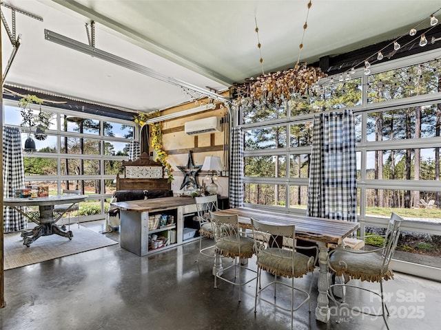 dining room with a wealth of natural light, finished concrete flooring, and an AC wall unit