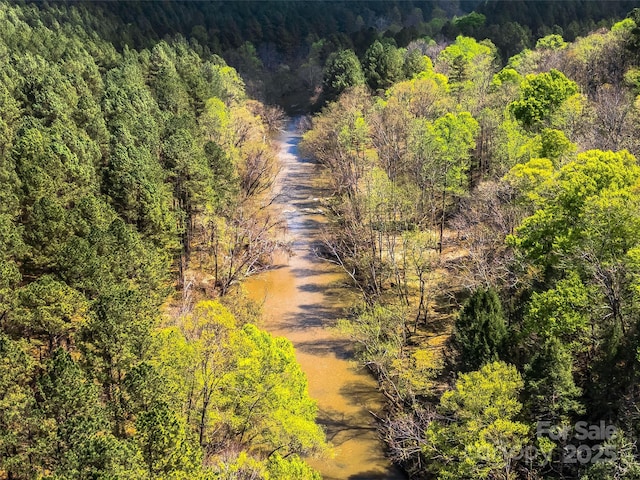 birds eye view of property featuring a view of trees